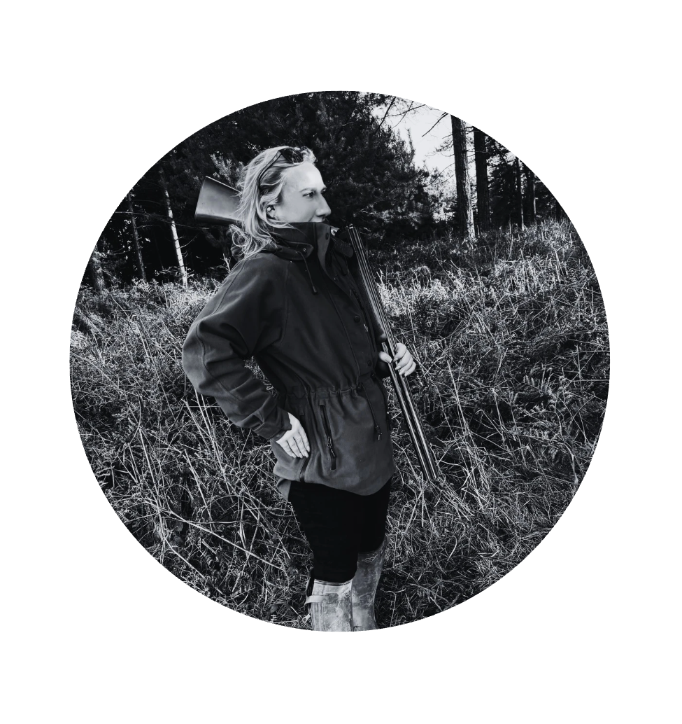 Person holding a rifle in a forest setting